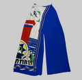 A pair of wide-leg pants laid flat on a textured white surface. The pants feature a royal blue right leg and a left leg with a complex multicolor graphic print including red, green, yellow, black, and white, with a vertical white stripe bordered in blue down the center.